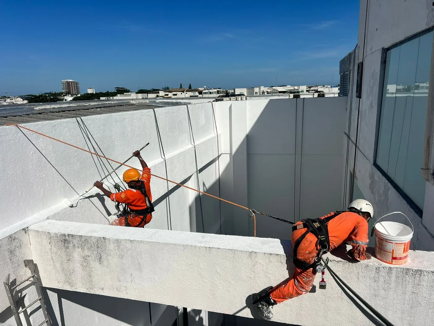 Equipe executando pintura em altura em edifício